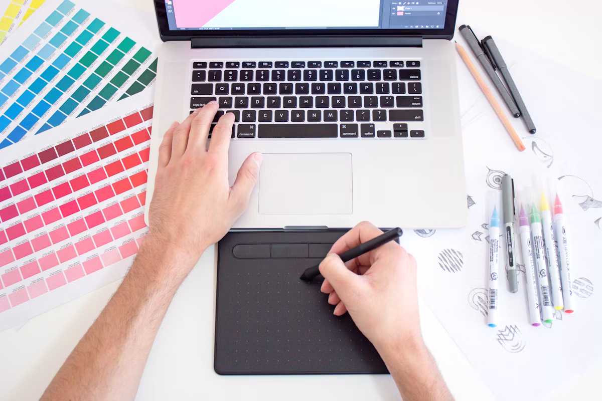 Professional graphic designer using Photoshop and Illustrator on workstation